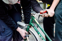 Mann mit Zange repariert Fahrrad