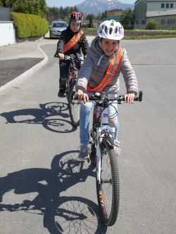 2 Kinder mit Reflexschärpen fahren Fahrrad