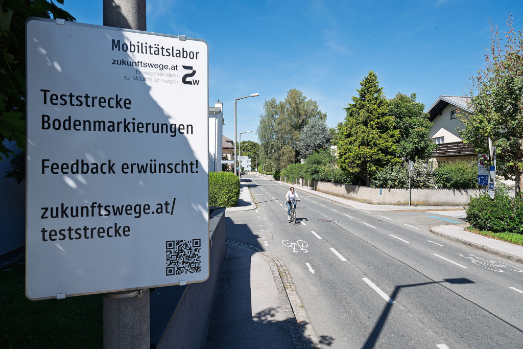 Straßenschild mit Hinweis auf Teststrecke für Bodenmarkierungen
